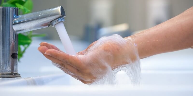 washing hands under powerful tap